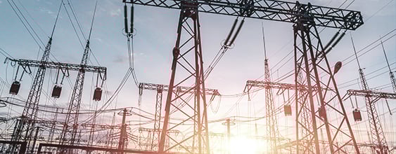 Overhead power lines with setting sun in background