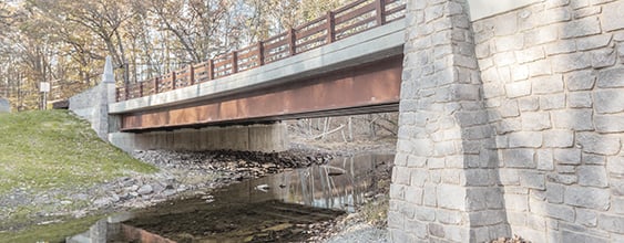 Bridge in a wooded area crossing over a small natural creek